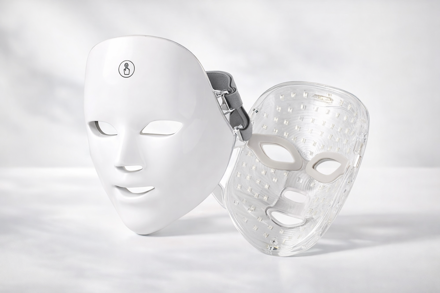 White LED face mask and clear face mask on a light gray background